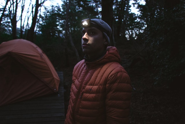 Hiker using a headlamp outdoors at dusk