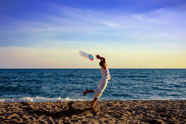 Flying disc game on sand near the beach